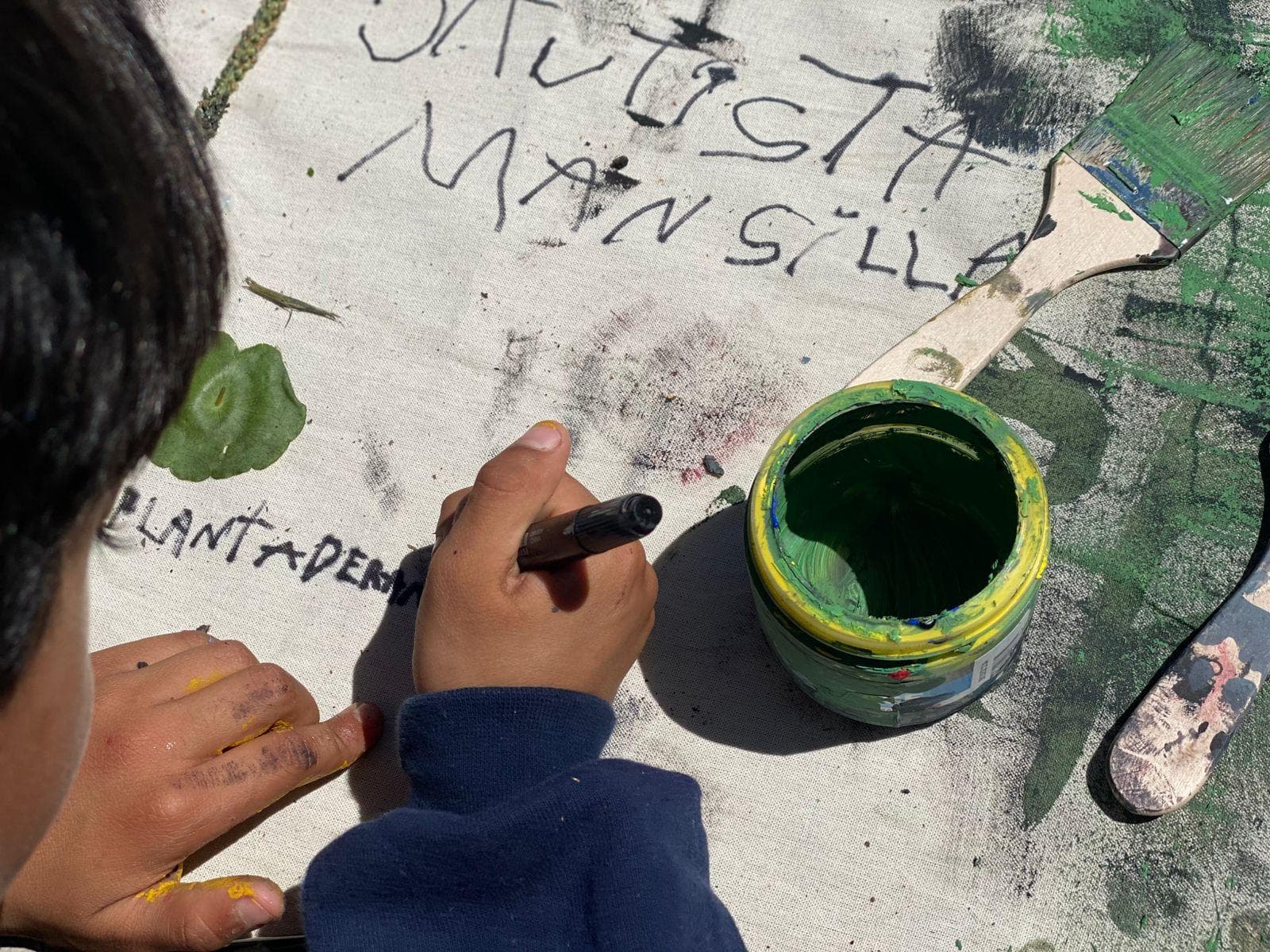 Chicos armando y pegando su propia obra en el taller.